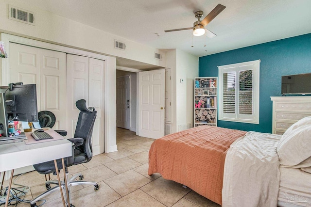 bedroom featuring light tile patterned floors, visible vents, and a closet