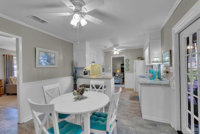 dining area with ceiling fan and ornamental molding