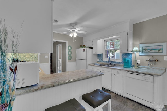 kitchen featuring white cabinets, kitchen peninsula, white appliances, and sink