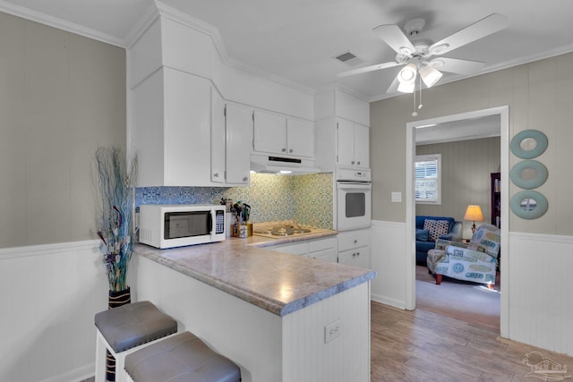 kitchen featuring white cabinets, light hardwood / wood-style floors, white appliances, and kitchen peninsula