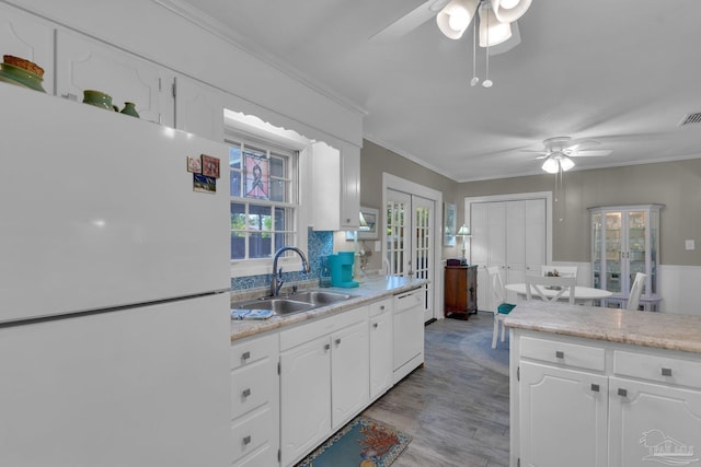 kitchen with white cabinetry, sink, plenty of natural light, white appliances, and light wood-type flooring