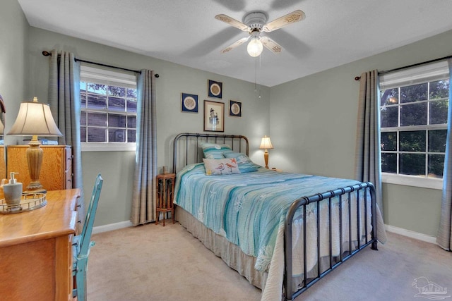 carpeted bedroom with ceiling fan and a textured ceiling