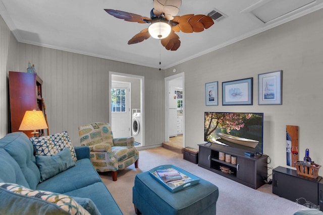 carpeted living room featuring washer / clothes dryer, ceiling fan, and ornamental molding