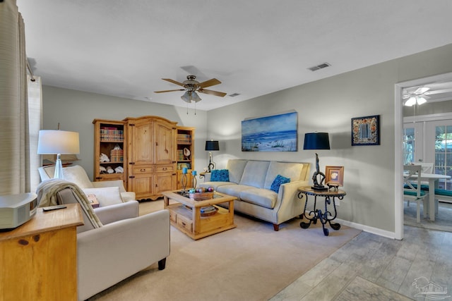 living room with light hardwood / wood-style floors and ceiling fan