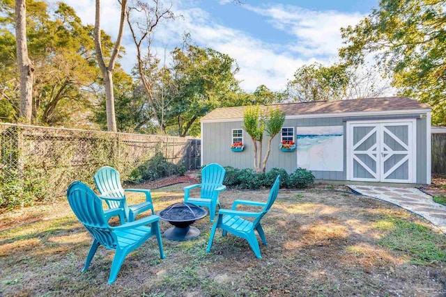 view of yard featuring a storage unit and an outdoor fire pit