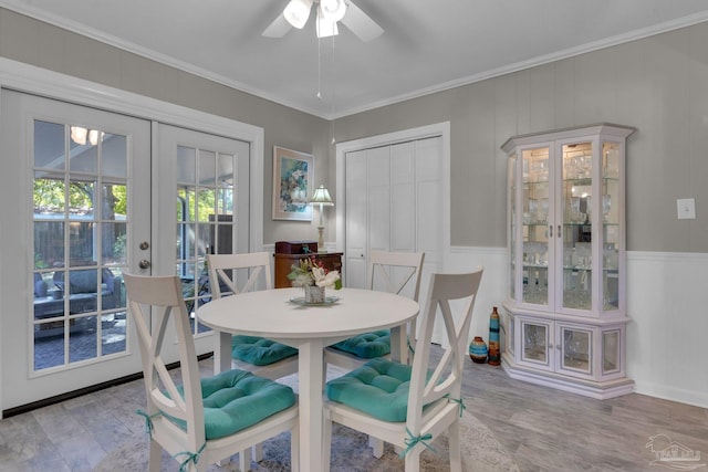 dining room with ceiling fan, wood-type flooring, ornamental molding, and french doors