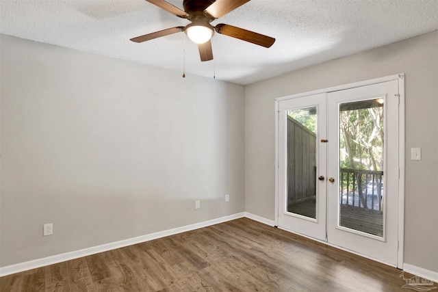 spare room featuring a textured ceiling, french doors, wood finished floors, and baseboards