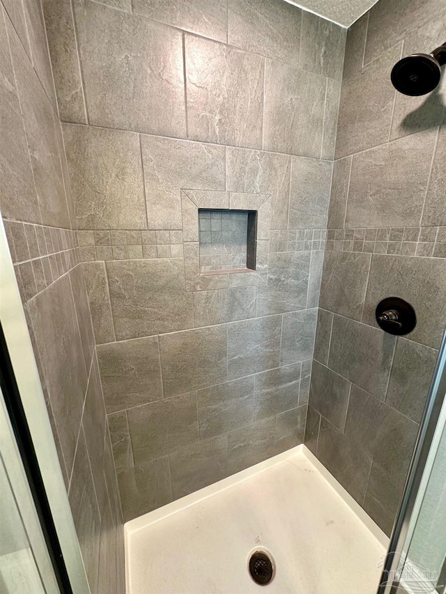 bathroom with a tile shower