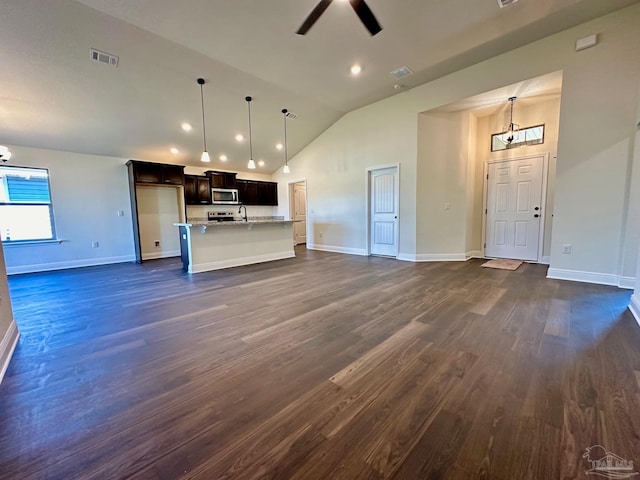 unfurnished living room with dark wood-type flooring, ceiling fan, and vaulted ceiling