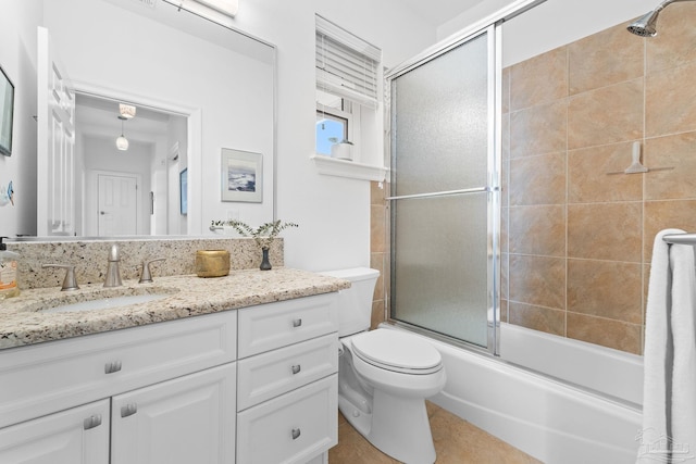 full bathroom featuring tile patterned floors, vanity, enclosed tub / shower combo, and toilet