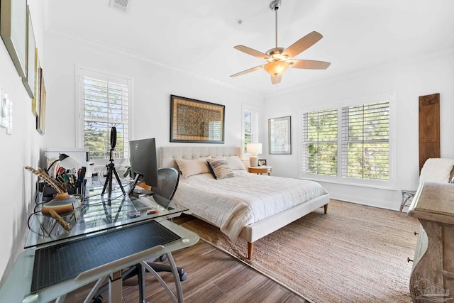 bedroom featuring ceiling fan, wood-type flooring, and ornamental molding