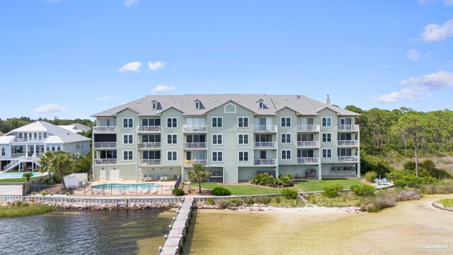 exterior space with a water view and a community pool