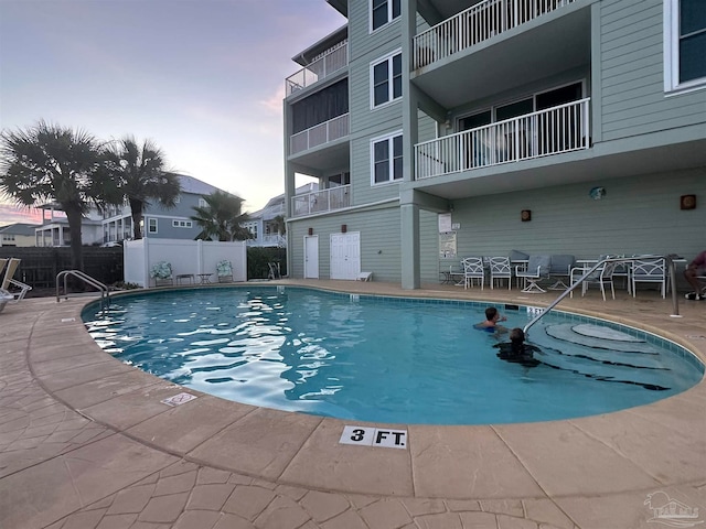 pool at dusk with a patio