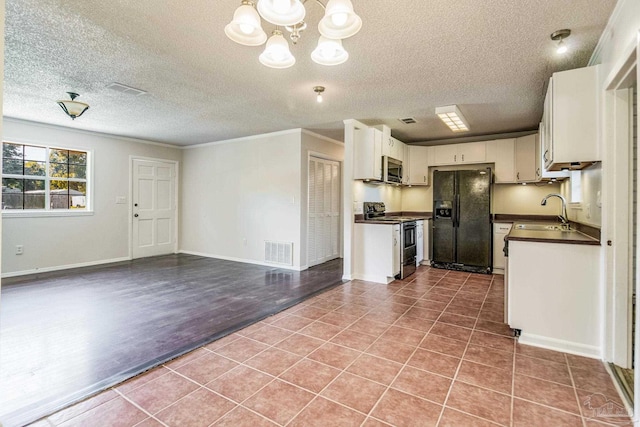 kitchen with sink, white cabinets, tile patterned flooring, ornamental molding, and stainless steel appliances