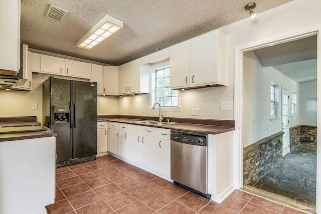 kitchen featuring sink, white cabinets, dark tile patterned flooring, stainless steel dishwasher, and black fridge with ice dispenser