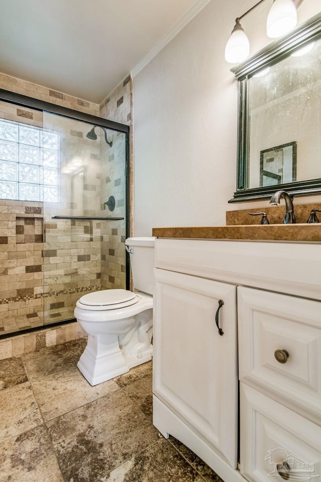 bathroom with vanity, a shower with door, ornamental molding, and toilet