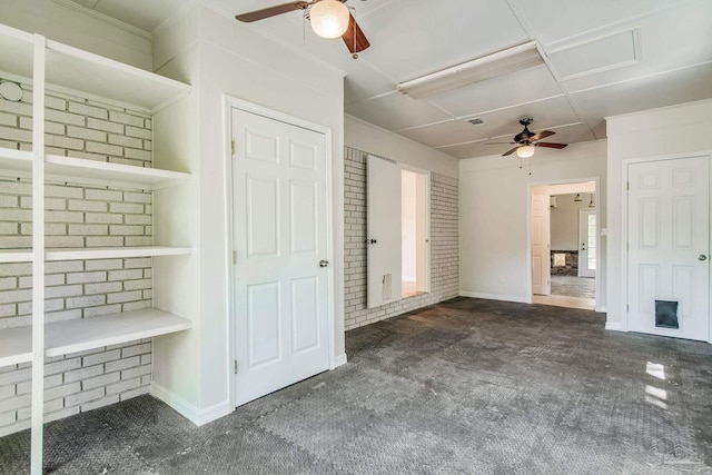 interior space with built in shelves, ceiling fan, and brick wall