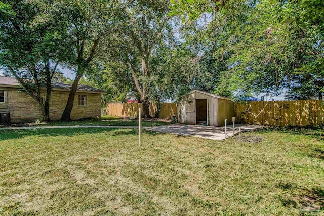 view of yard with central AC, a storage unit, and a patio