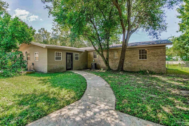 ranch-style house with central AC unit and a front yard