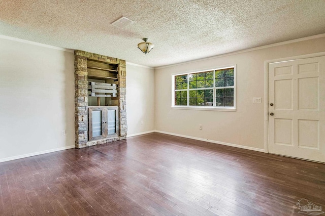 unfurnished living room featuring dark hardwood / wood-style flooring, a stone fireplace, ornamental molding, and a textured ceiling