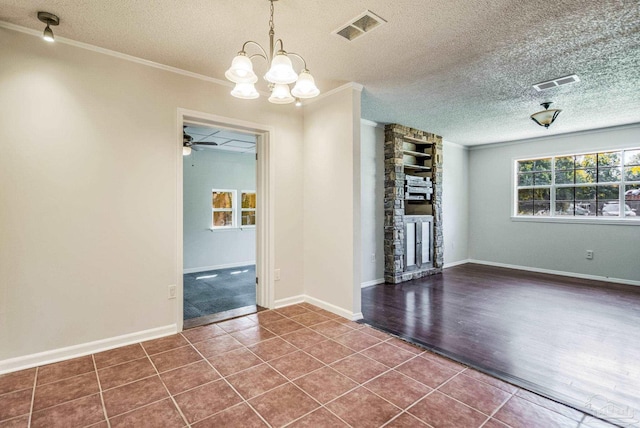 interior space with crown molding, tile patterned floors, ceiling fan with notable chandelier, and a textured ceiling