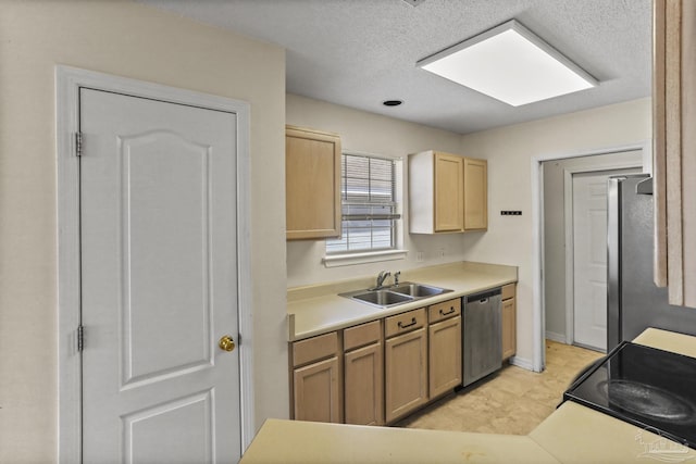 kitchen with appliances with stainless steel finishes, sink, light brown cabinetry, and a textured ceiling