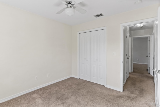 unfurnished bedroom with a closet, ceiling fan, and light colored carpet