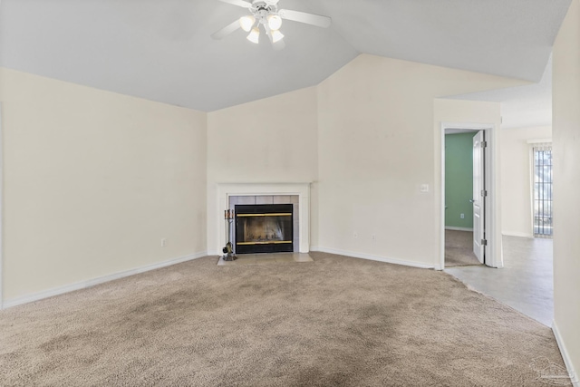 unfurnished living room with a tiled fireplace, lofted ceiling, light carpet, and ceiling fan