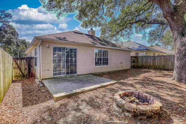 rear view of property with a patio area and a fire pit