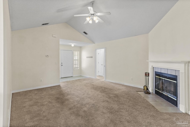 unfurnished living room featuring ceiling fan, high vaulted ceiling, light colored carpet, and a tiled fireplace