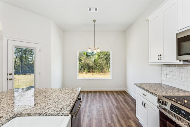 6575 Gentle Rain Dr, Milton, FL 32570 - kitchen featuring stainless steel appliances, dark wood-type flooring, a chandelier, light stone counters, and baseboards