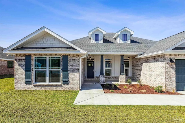 6575 Gentle Rain Dr, Milton, FL 32570 - view of front of house featuring covered porch, roof with shingles, brick siding, and a front lawn