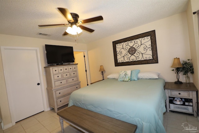 tiled bedroom featuring a textured ceiling and ceiling fan