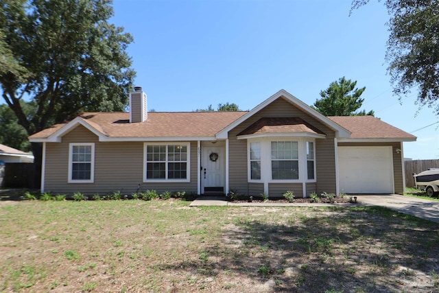 ranch-style home with a garage and a front lawn