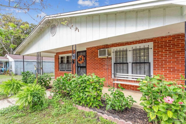 6598 Magnolia St, Milton, FL 32570 - view of front of property featuring brick siding, a porch, and an AC wall unit