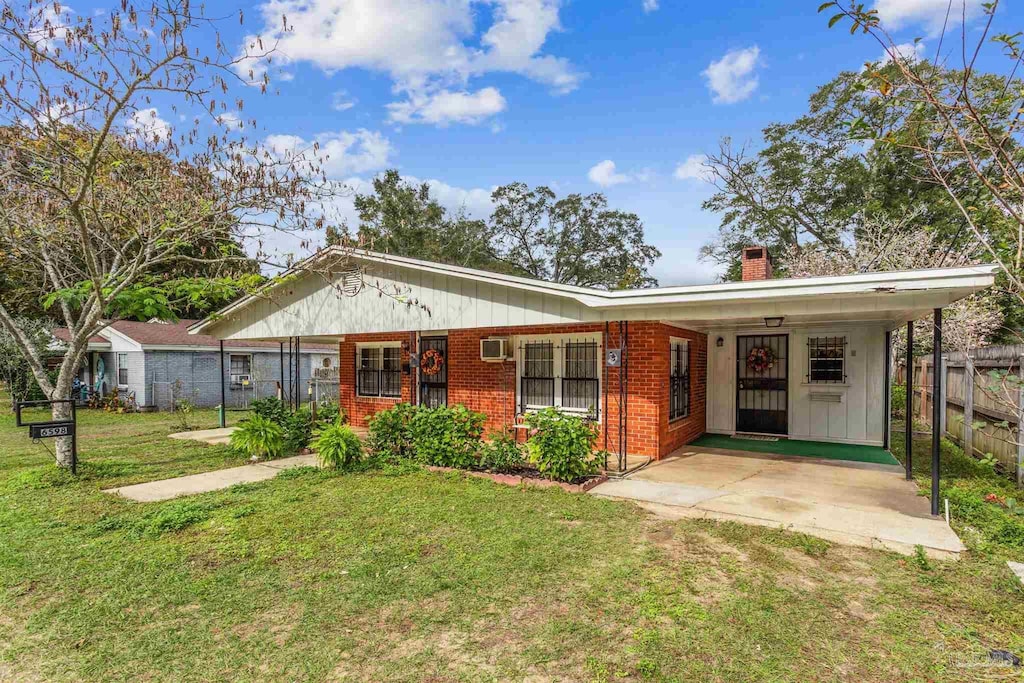 6598 Magnolia St, Milton, FL 32570 - view of front of property with a chimney, brick siding, a wall mounted AC, and board and batten siding