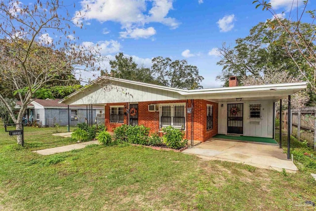 6598 Magnolia St, Milton, FL 32570 - view of front of property with a chimney, brick siding, a wall mounted AC, and board and batten siding