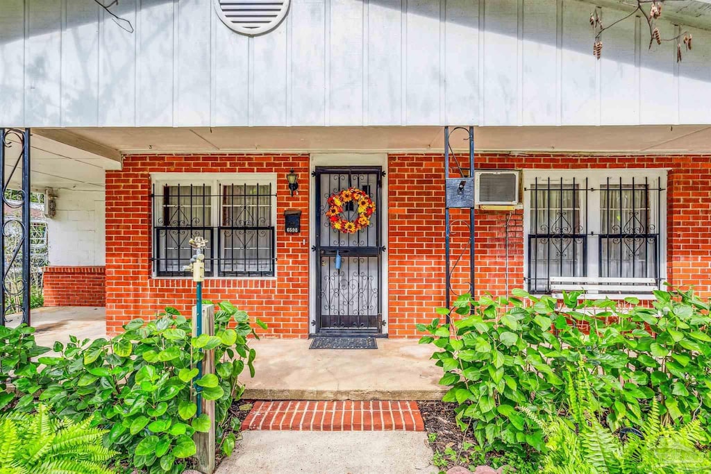 6598 Magnolia St, Milton, FL 32570 - view of exterior entry featuring a porch and brick siding