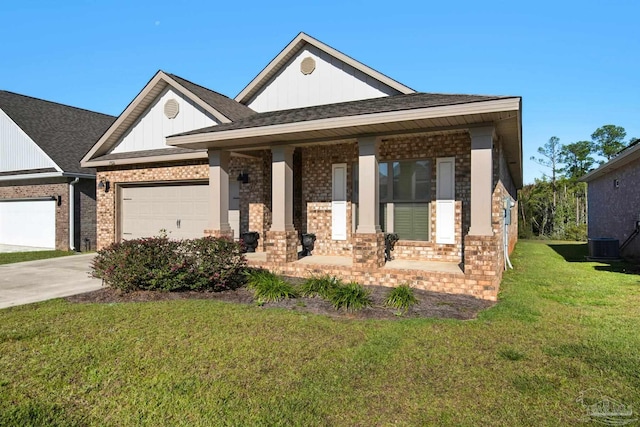 view of front of house with covered porch, a front yard, and a garage