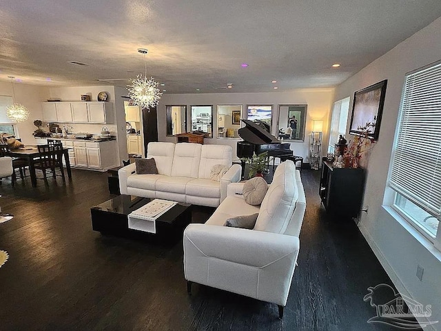 living area with an inviting chandelier, baseboards, dark wood finished floors, and recessed lighting