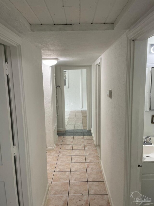 hall with sink and light tile patterned floors