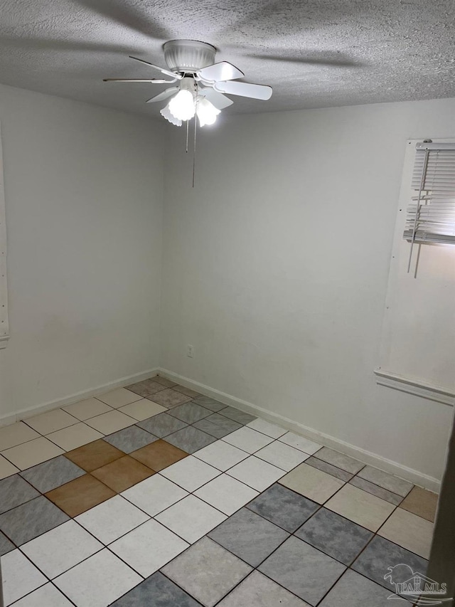 unfurnished room featuring ceiling fan, light tile patterned floors, and a textured ceiling