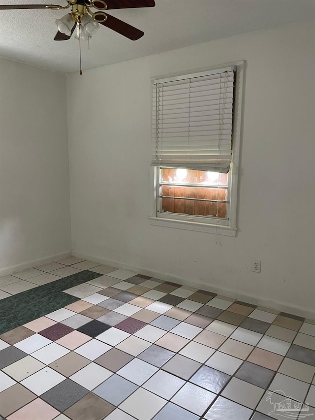 spare room featuring ceiling fan and light tile patterned floors