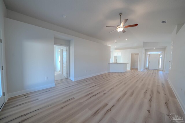 unfurnished living room featuring vaulted ceiling, ceiling fan, and light hardwood / wood-style flooring