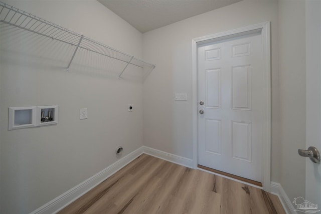 clothes washing area with electric dryer hookup, washer hookup, and light hardwood / wood-style floors