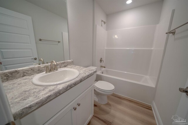 full bathroom with vanity, toilet, hardwood / wood-style floors, and shower / bathing tub combination