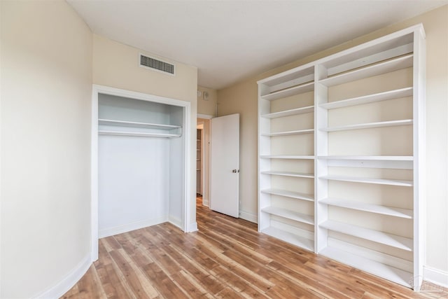 unfurnished bedroom with a closet and wood-type flooring