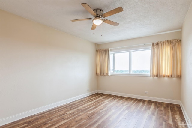 unfurnished room with ceiling fan, wood-type flooring, and a textured ceiling