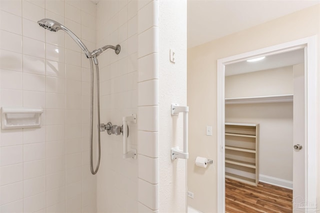 bathroom with hardwood / wood-style flooring and tiled shower