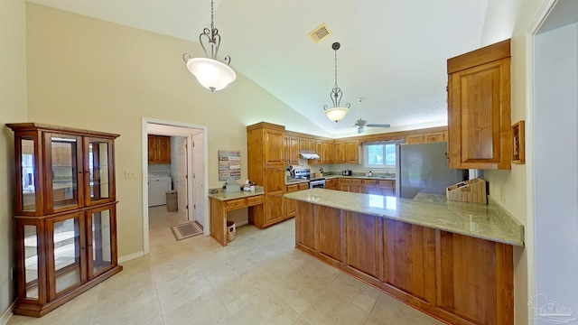 kitchen featuring stainless steel appliances, decorative light fixtures, kitchen peninsula, and washer / dryer